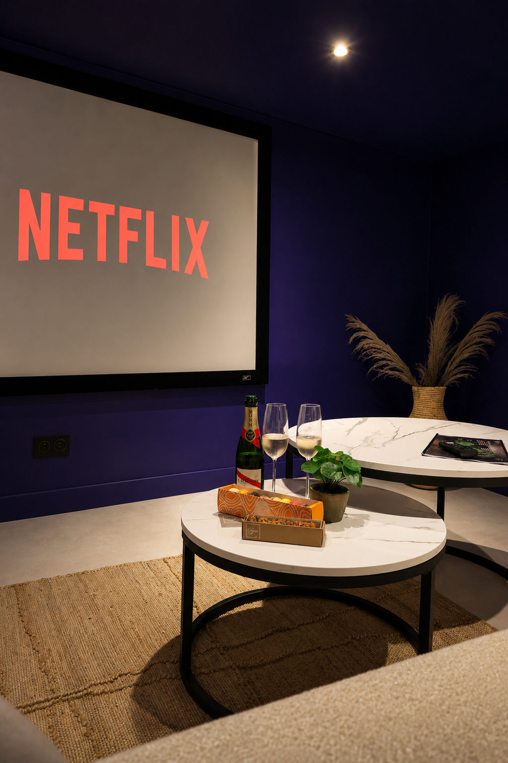 L’espace cinéma du Loft, avec son grand écran et ses tables basses devant le canapé